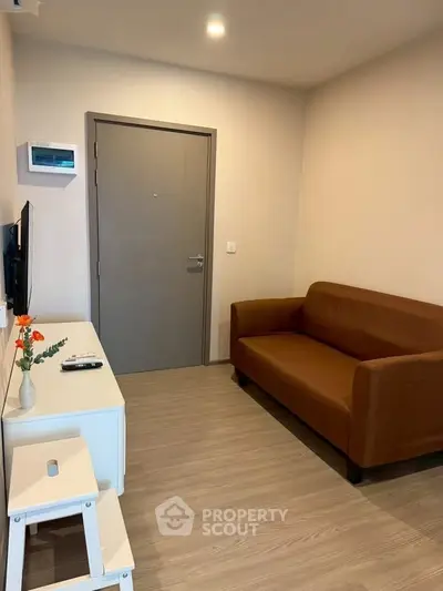 Cozy living room with brown sofa and modern decor in a compact apartment.