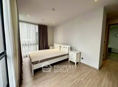 Spacious bedroom with modern decor and large windows for natural light.