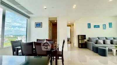 Spacious modern living room with large windows and elegant dining area.