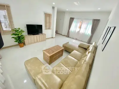 Spacious modern living room with beige leather sectional and natural light
