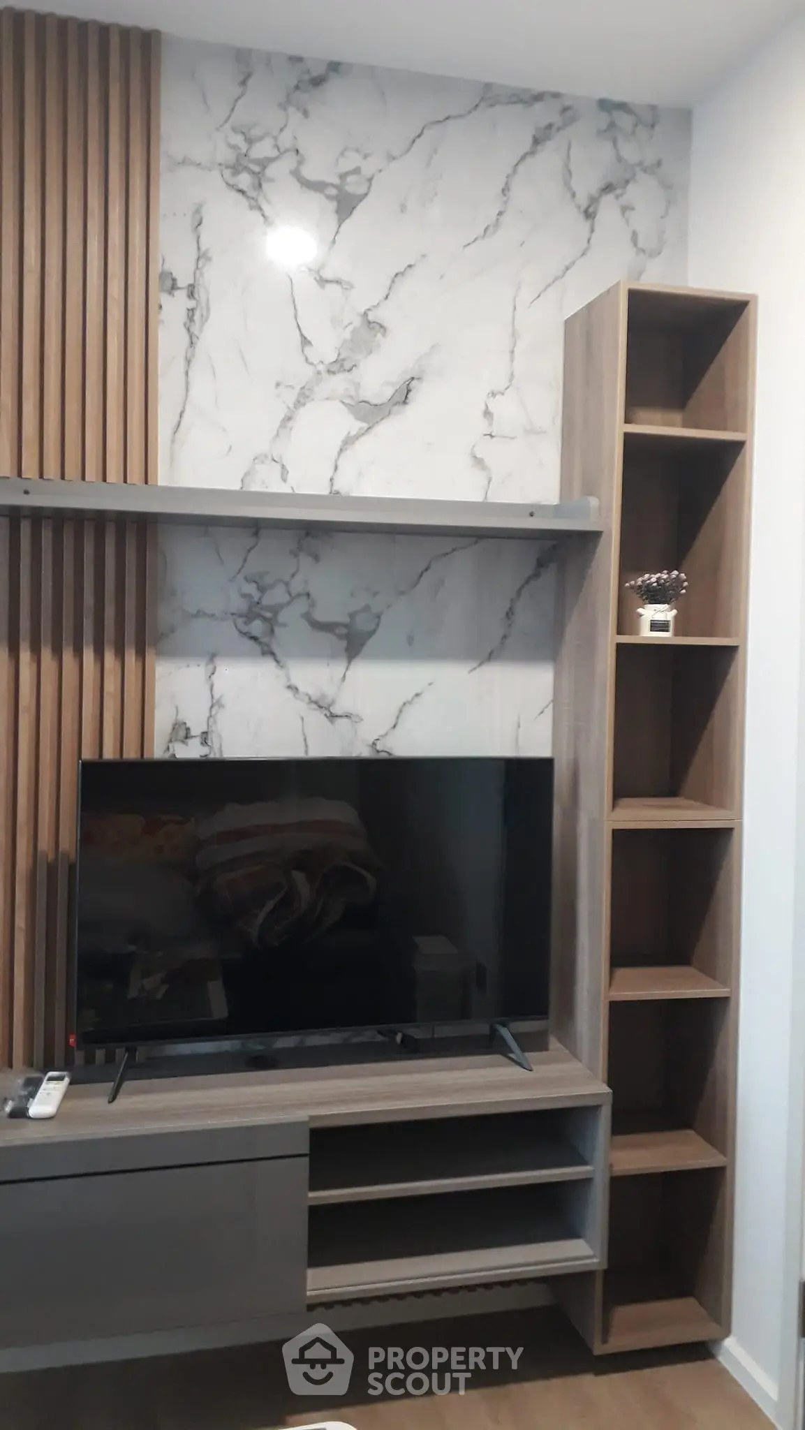 Modern living room with stylish TV unit and marble accent wall