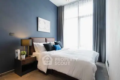 Modern bedroom with stylish decor and large window for natural light
