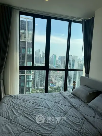 Luxurious bedroom with stunning city view from floor-to-ceiling windows in a high-rise apartment.