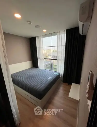 Cozy bedroom with large window and modern decor in urban apartment