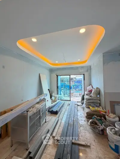 Spacious under-construction living room with modern ceiling lights and large windows.