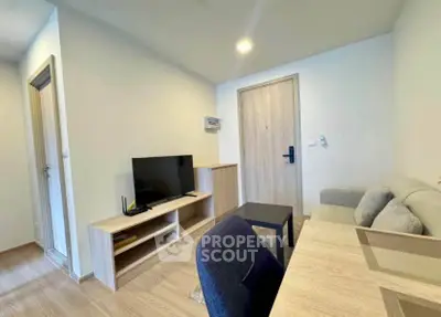 Modern living room with sleek furniture and flat-screen TV in a cozy apartment setting.