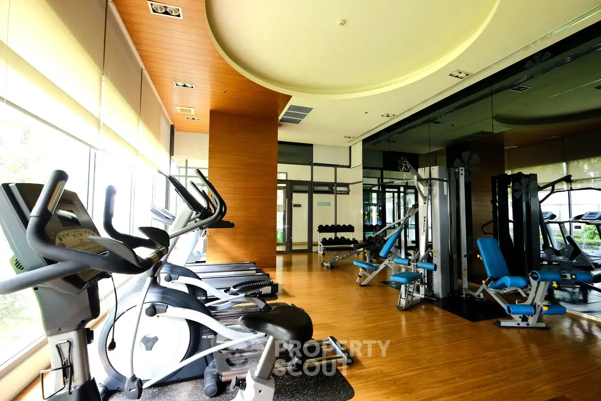 Spacious modern gym with state-of-the-art fitness equipment and mirrored walls.