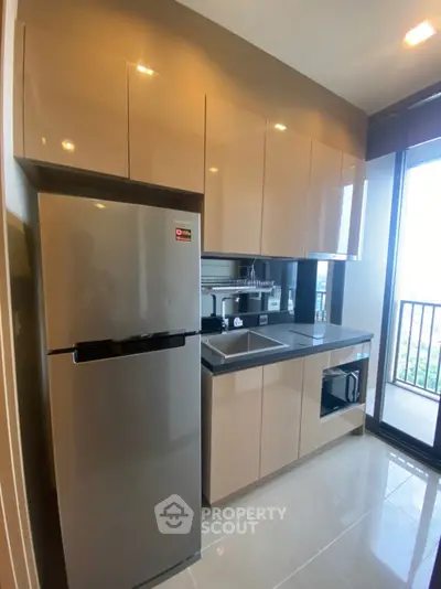 Modern kitchen with sleek cabinets and stainless steel appliances in a high-rise apartment.