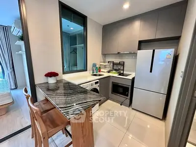 Modern kitchen with sleek appliances and stylish breakfast bar in a compact layout.