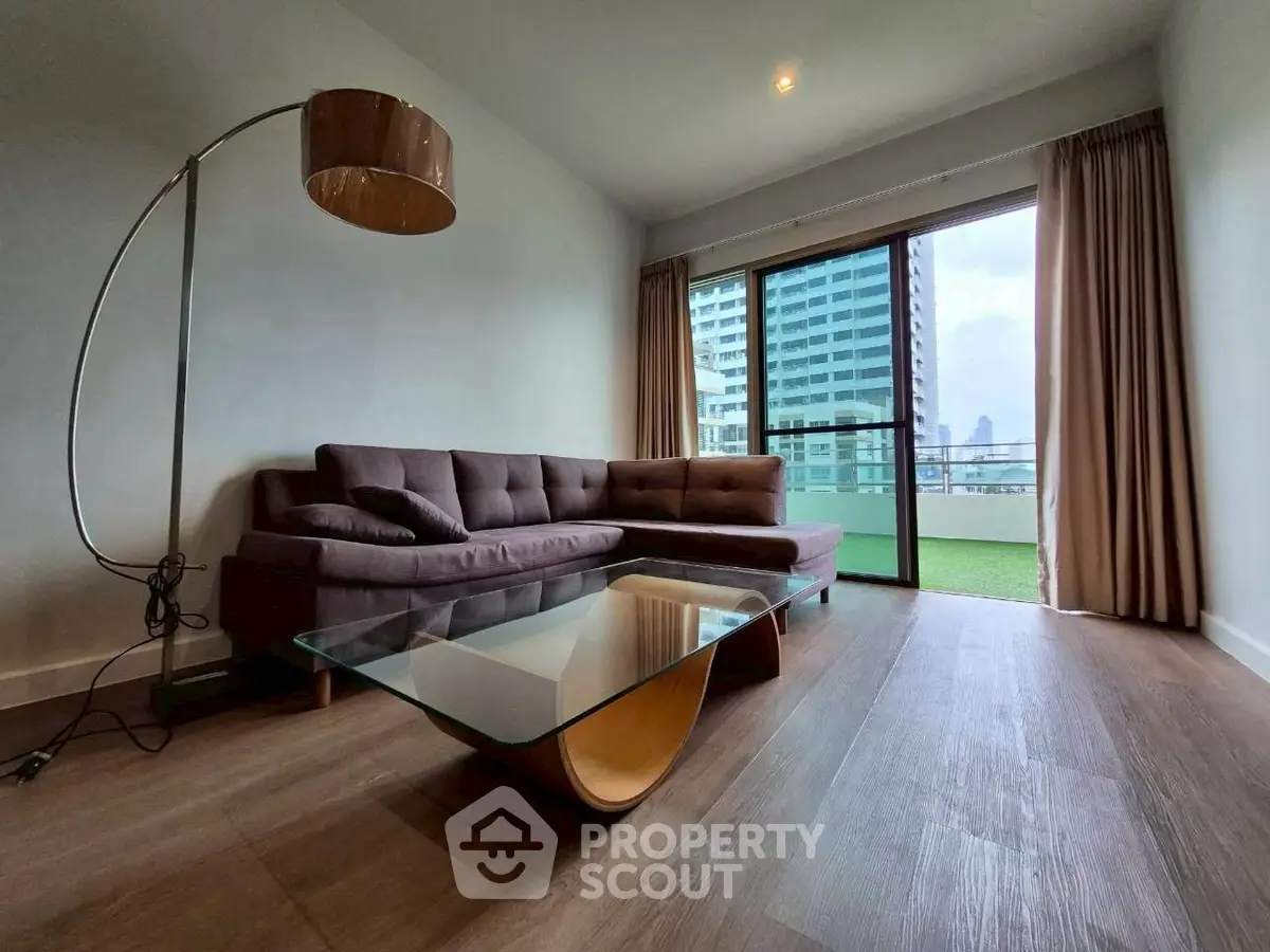 Modern living room with stylish furniture and large window offering city view
