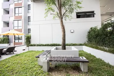 Modern apartment building with landscaped garden and seating area