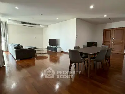 Spacious living room with modern furniture and wooden flooring in a luxury apartment.