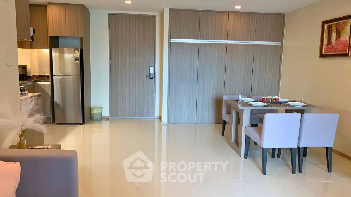 Modern open-plan living area with sleek kitchen and dining space, featuring elegant decor and ample natural light.