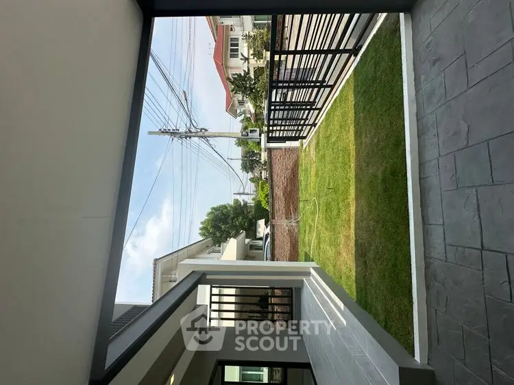 Modern home entrance with landscaped garden and sleek metal fencing.