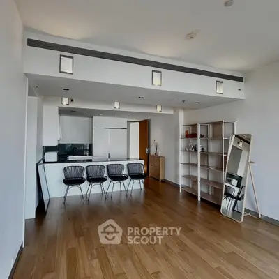 Spacious modern living room with open kitchen and sleek wooden flooring