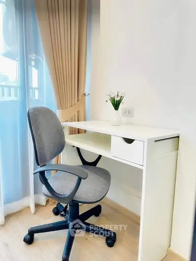 Cozy study nook with modern desk and chair by a sunlit window.