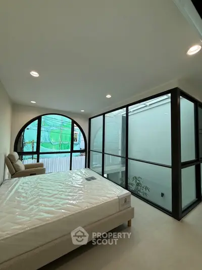 Modern bedroom with large windows and natural light