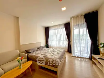 Spacious bedroom with modern decor and large windows offering natural light.