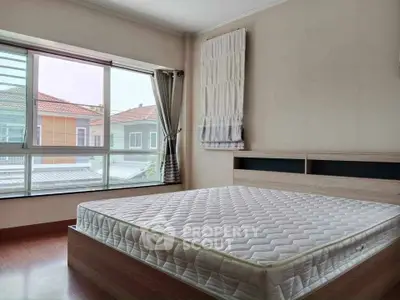 Spacious bedroom with large window and natural light in modern home