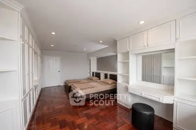 Spacious bedroom with elegant wooden flooring and built-in storage solutions.