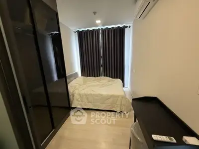 Cozy bedroom with modern furnishings and large window, perfect for relaxation and comfort.