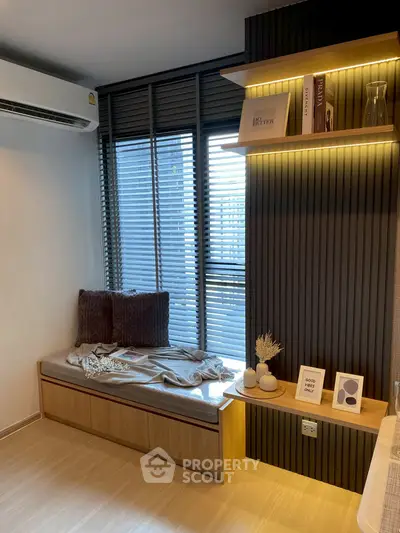 Cozy modern living room corner with window seat and stylish shelving.