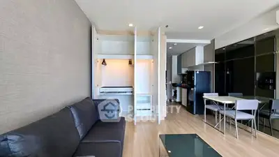 Modern open-plan living room with sleek kitchen and stylish furnishings in a contemporary apartment.