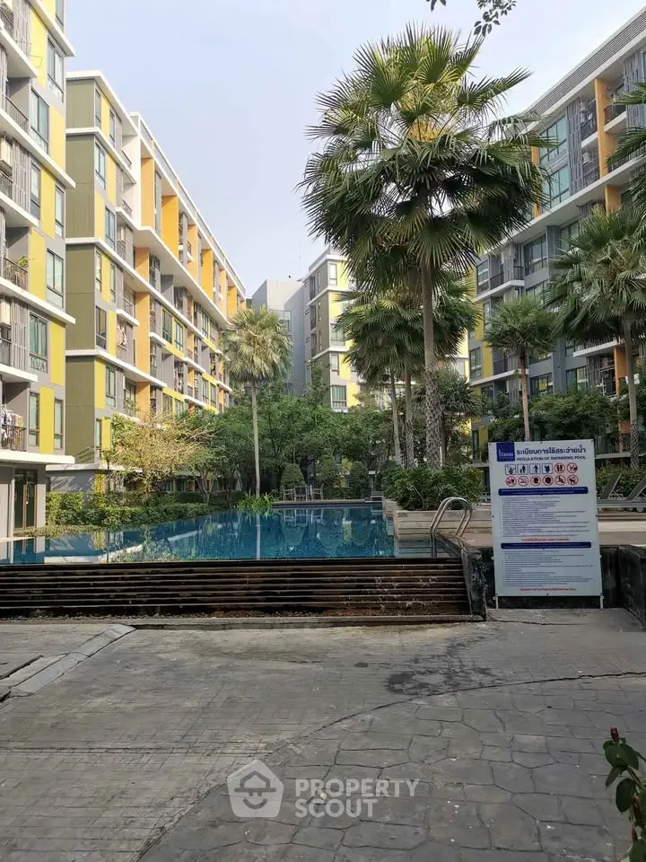 Modern apartment complex with pool and lush greenery, perfect for urban living.