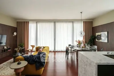 Luxurious modern living room with elegant decor and open layout, featuring a stylish kitchen and large windows.