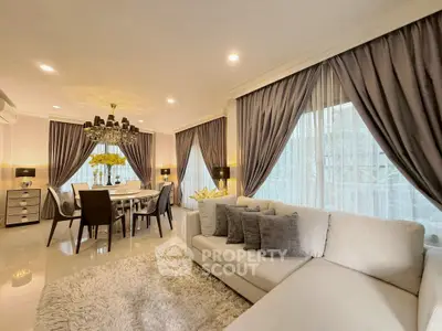 Luxurious living room with elegant dining area, plush sofa, and chic decor in a modern home.