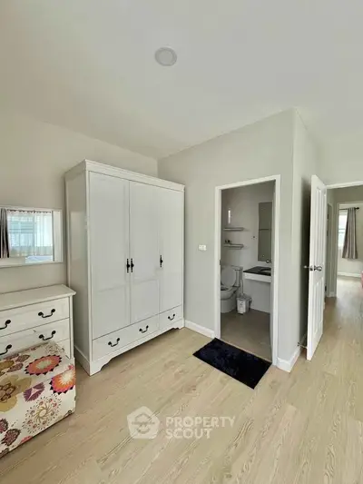 Spacious bedroom with elegant wardrobe and ensuite bathroom in modern apartment