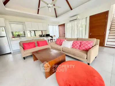 Spacious living room with modern furniture and open kitchen layout in a stylish home.