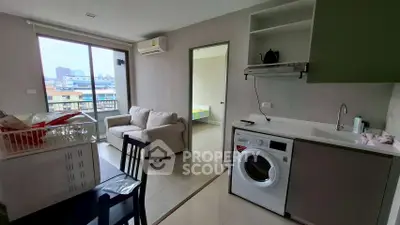 Modern apartment with open layout, featuring a cozy living area, washing machine, and city view.