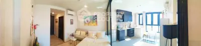 Modern open-layout living room and kitchen with bright natural light.