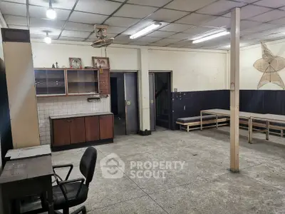 Spacious interior with potential for renovation, featuring open layout and ample lighting.