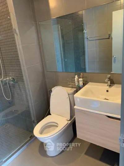 Modern bathroom with glass shower and sleek fixtures in a stylish apartment.