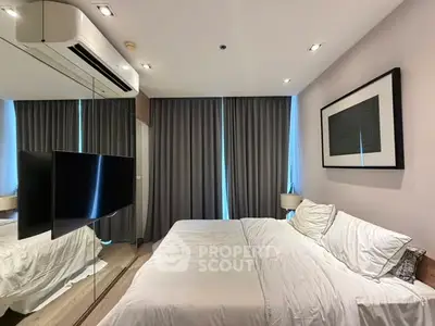 Modern bedroom with mirrored wall, sleek air conditioning, and elegant decor.