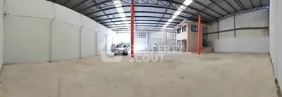 Spacious industrial warehouse with high ceilings and ample parking space.