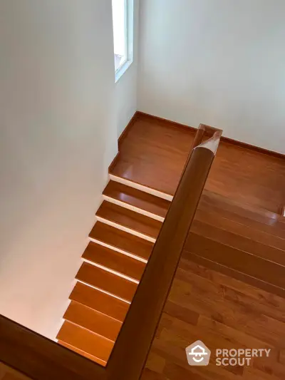 Elegant wooden staircase with natural light in modern home interior