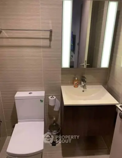 Modern bathroom with sleek fixtures and illuminated mirror in a contemporary apartment.