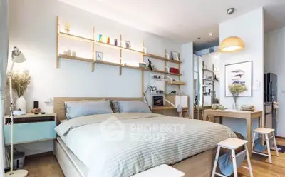 Modern bedroom with stylish shelving and cozy dining area in open-plan apartment.
