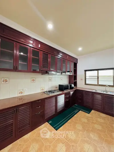 Spacious kitchen with wooden cabinets and modern appliances in a cozy home.