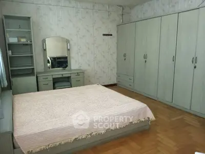 Spacious bedroom with ample storage and elegant parquet flooring