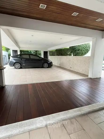 Spacious covered parking area with sleek wooden flooring and modern design.