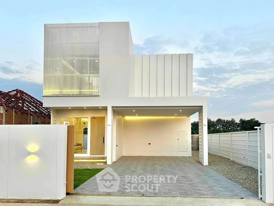 Modern minimalist white house with spacious driveway and sleek architectural design.