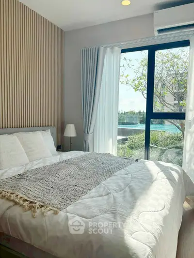 Bright and airy bedroom with modern decor and large window view.