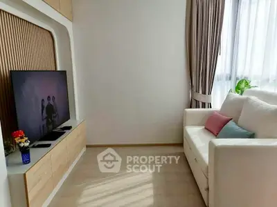 Modern living room with sleek TV setup and cozy white sofa