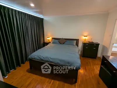 Spacious bedroom with elegant dark curtains and cozy lighting