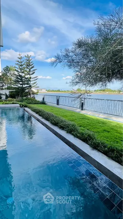 Luxurious waterfront property with stunning pool and lush greenery.