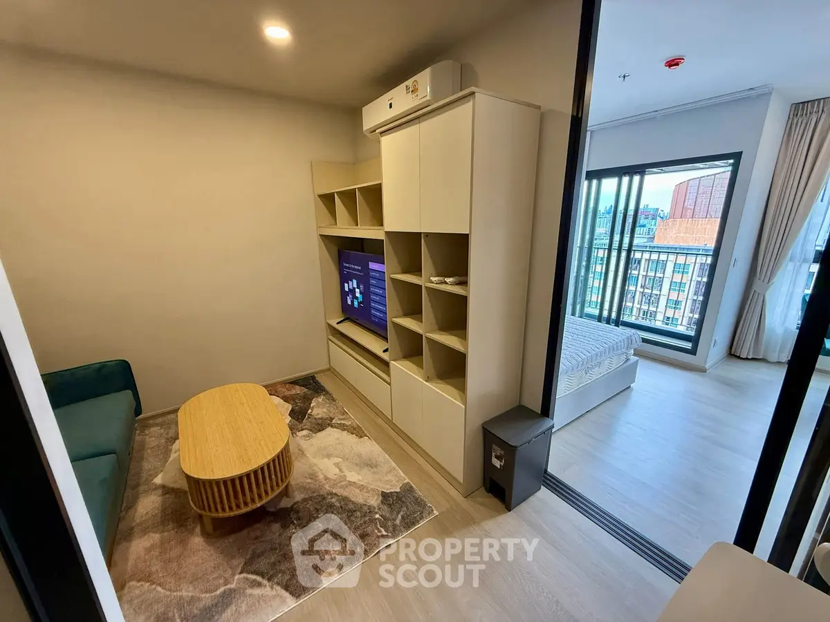 Modern living room with stylish furniture and open view to bedroom in a contemporary apartment.